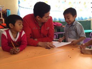 El delegado del conafe e, Yucatán, Carlos Carrillo Paredes, conversa con pequeños infantes en un salón de una escuela comunitaria